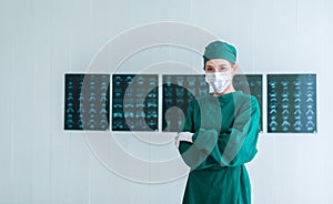 Portrait of Female doctor Surgeon in green scrubs putting on surgical gloves and looking at Camera . Young asian doctor woman with