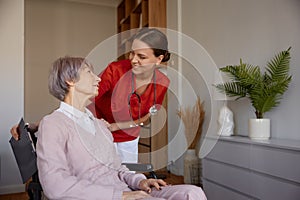 Portrait of female doctor talking to her patient during home visit