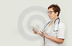 Portrait of a female doctor using her digital tablet. Female doctor using tablet and checking with analysis