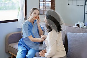 Portrait of a female doctor using a stethoscope to check the pulse of an elderly patient.