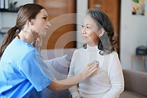 Portrait of a female doctor using a stethoscope to check the pulse of an elderly patient.