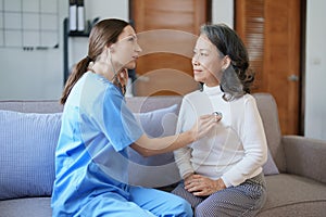 Portrait of a female doctor using a stethoscope to check the pulse of an elderly patient.