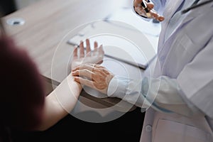 Portrait of a female doctor using a stethoscope to check the pulse of an elderly patient.