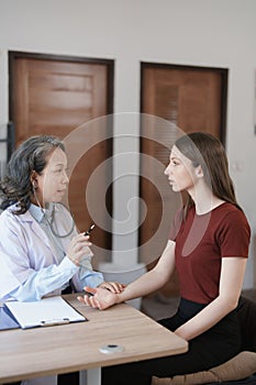 Portrait of a female doctor using a stethoscope to check the pulse of an elderly patient.