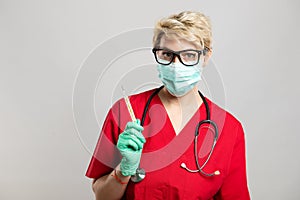 Portrait of female doctor wearing face mask showing thermometer