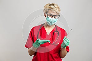 Portrait of female doctor wearing face mask showing thermometer