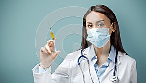 Portrait of female doctor wearing protective mask and gloves holding a syringe