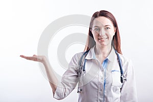 Portrait of a female doctor in a white uniform that shows a palm with copyspace in the studio on a white background.