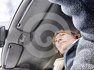 Portrait of female driver in solo journey. Adult mature woman holding steering wheel and looking through windscreen in