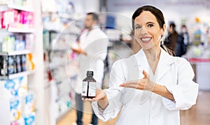 Portrait of female druggist advertising medicine