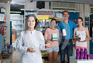 portrait of female druggist in white coat working in pharmacy