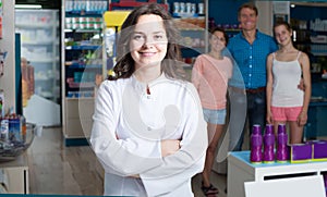 Portrait of female druggist in white coat working in pharmacy
