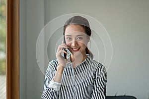 Portrait Female Entrepreneur. Cheerful asian Businesswoman Talking On Phone In Modern Office.