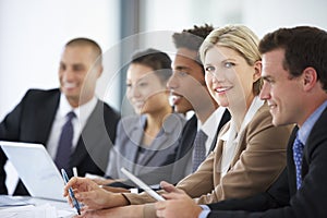 Portrait Of Female Executive Attending Office Meeting With Colleagues