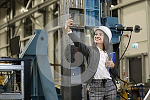 Portrait of a female factory manager in a business suit holding notebook, controlling the work process in the manufacture