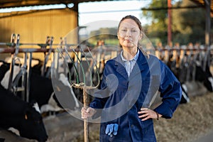Portrait of female farm owner in cowshed photo