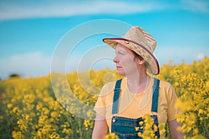 Portrait of female farmer agronomist in blooming rapeseed crops field