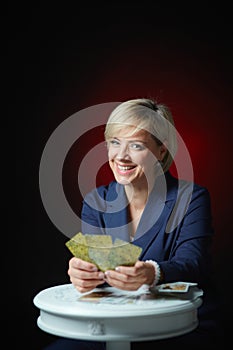 Portrait of a female fortune teller with tarot cards, on a black background