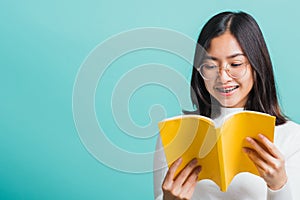 Portrait female in glasses is holding and reading a book