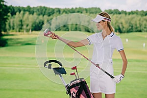 portrait of female golf player in cap with golf gear