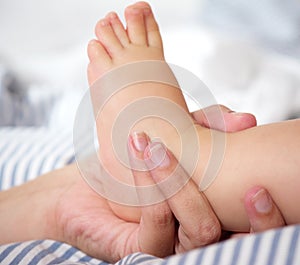 Portrait of female hand holding baby foot