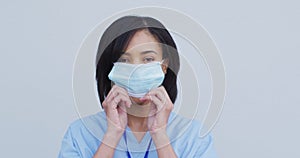 Portrait of Female health worker wearing face mask against white background