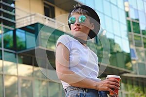 Portrait of female hipster with natural makeup and short haircut enjoying leisure time outdoors