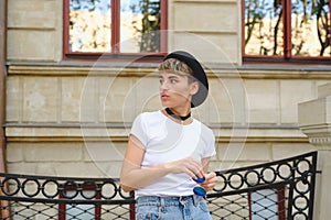 Portrait of female hipster with natural makeup and short haircut enjoying leisure time outdoors