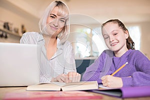 Portrait Of Female Home Tutor Helping Young Girl With Studies photo