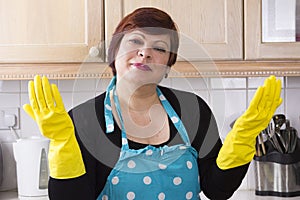 Portrait of female houseworker dusting kitchen