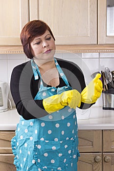 Portrait of female houseworker dusting kitchen