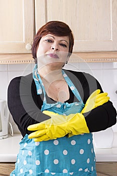 Portrait of female houseworker dusting kitchen