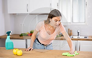 Portrait of female houseworker dusting kitchen surfaces