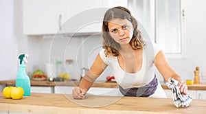 Portrait of female houseworker dusting kitchen surfaces