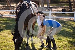 Portrait of female jockey assisting girl