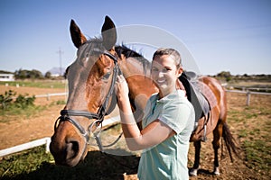 Portrait of female jockey fastening bridle