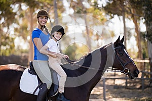 Portrait of Female jockey and girl sitting horseback riding