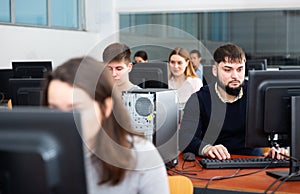Portrait of female and male students working on computers in classroom