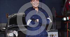 Portrait of female mechanic with arms crossed smiling at a car service station