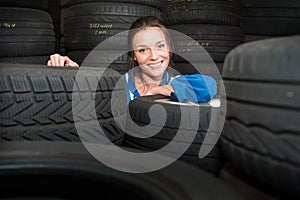 Portrait of a female mechanic,surrounded by car tyres