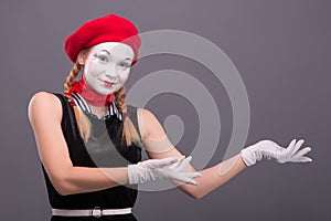 Portrait of female mime with red hat and white