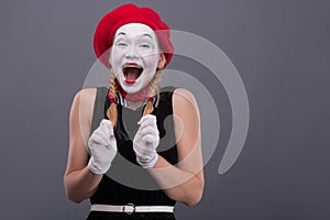 Portrait of female mime with red hat and white