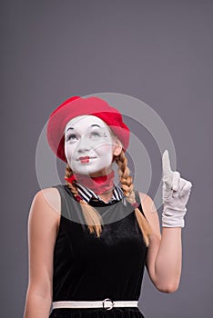 Portrait of female mime with red hat and white