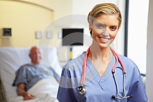 Portrait Of Female Nurse With Patient In Background