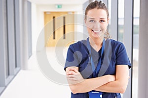 Portrait Of Female Nurse Standing In Hospital Corridor photo