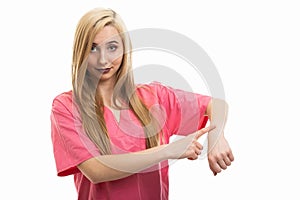 Portrait of female nurse wearing scrubs making late gesture