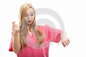 Portrait of female nurse wearing scrubs making time is money gesture