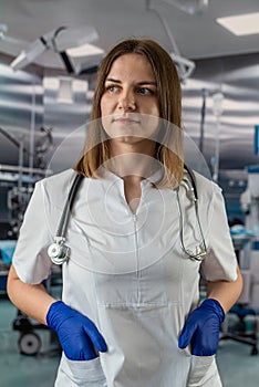 Portrait of female nurse in white uniform and stethoscope in operating room in hospital.