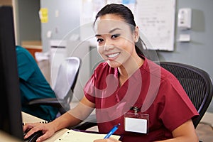 Portrait Of Female Nurse Working At Nurses Station photo