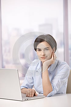 Portrait of female office worker with computer
